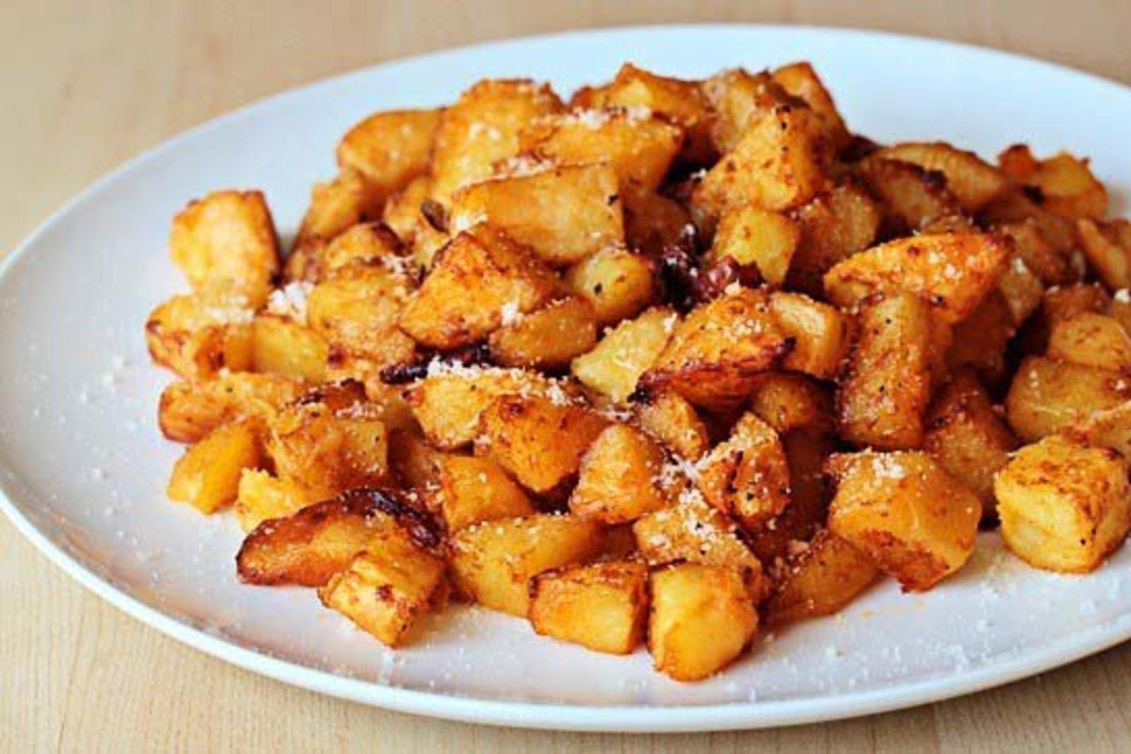 Жареная картошка посыпана пряными. Жареная картошка кубиками. Жареный картофель в духовке. Жареная картошка в духовке. Жареный картофель с сыром.